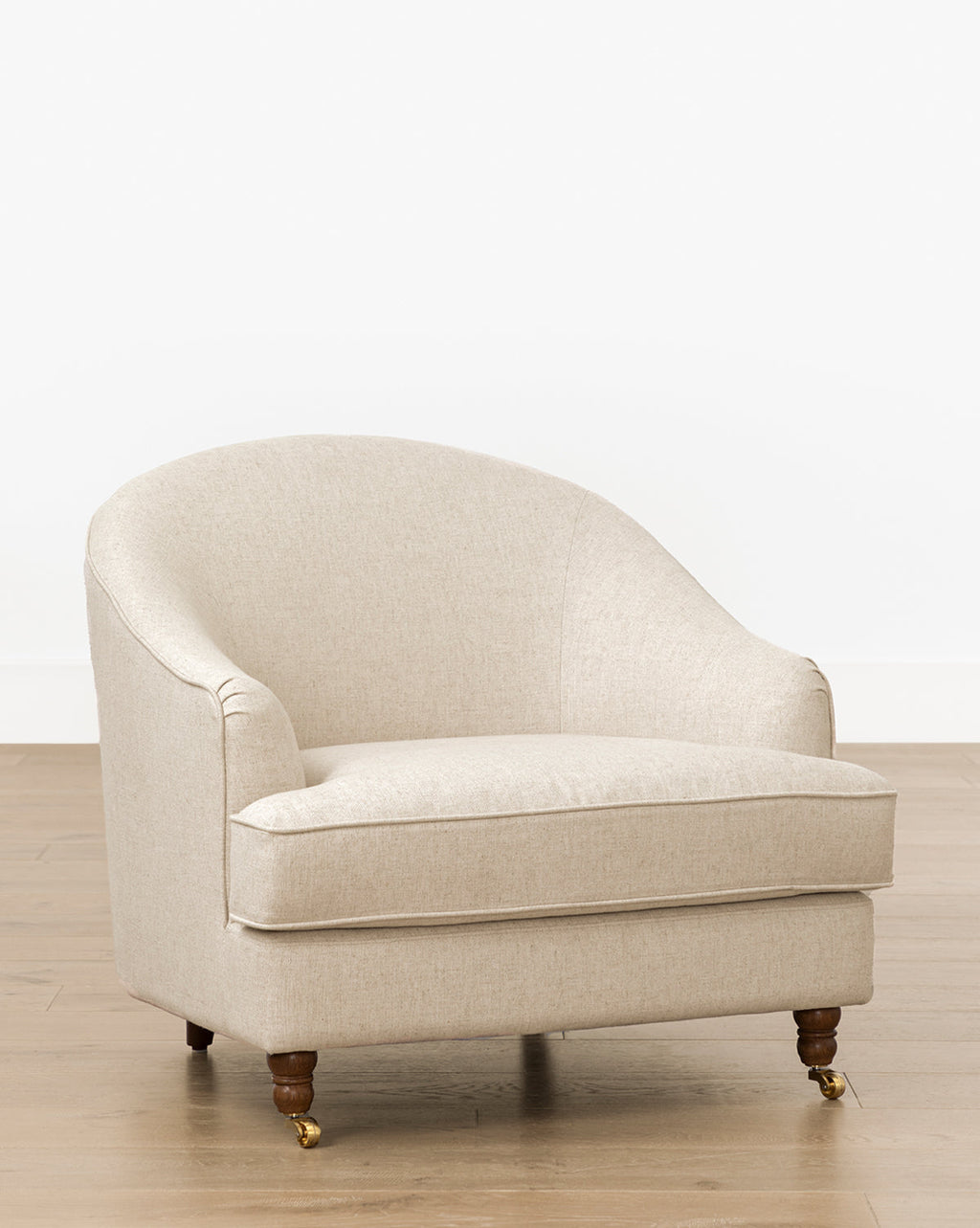 Fauteuil de salon classique capitonné avec accoudoirs roulés et pieds à roulettes pour salon