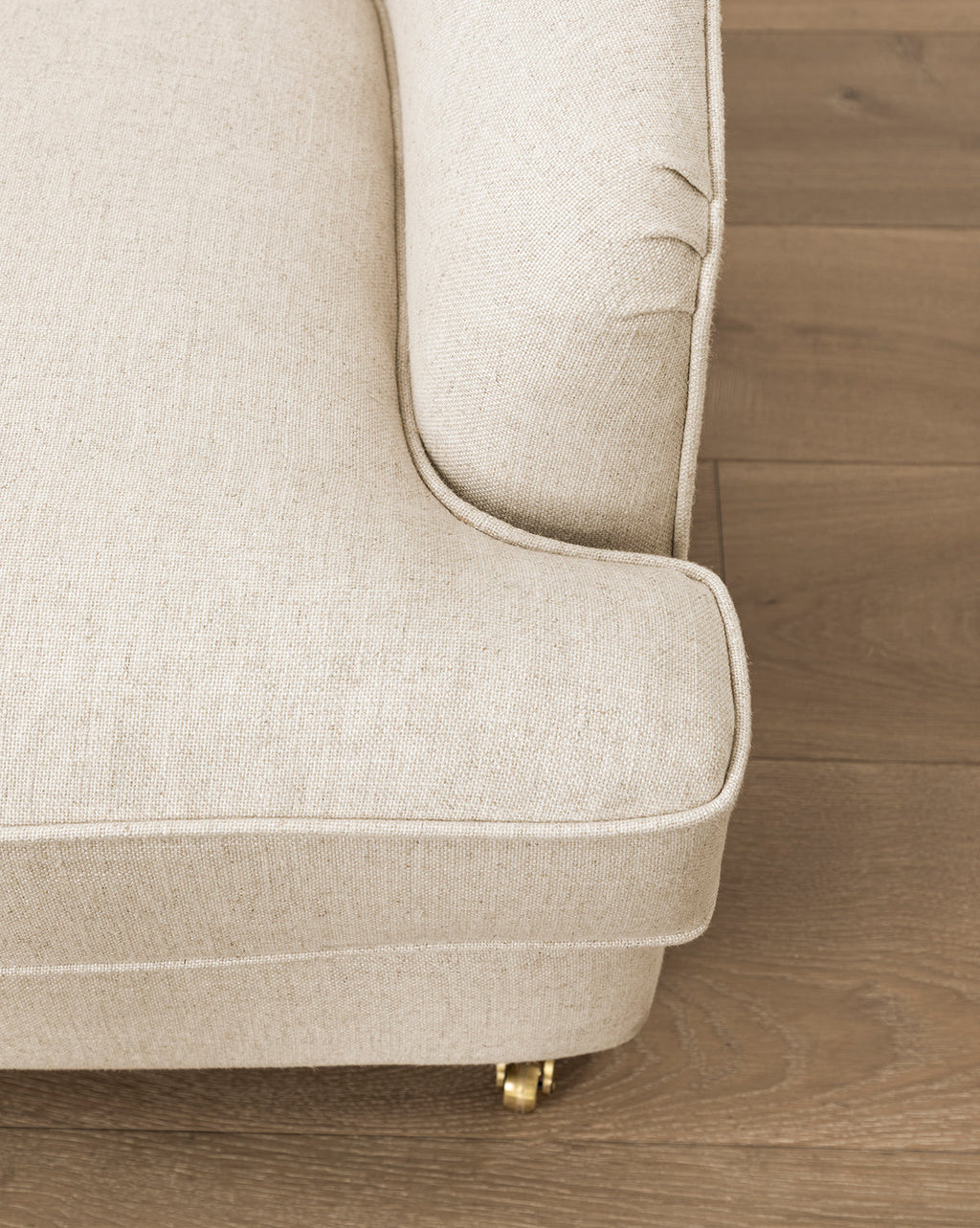 Fauteuil de salon classique capitonné avec accoudoirs roulés et pieds à roulettes pour salon