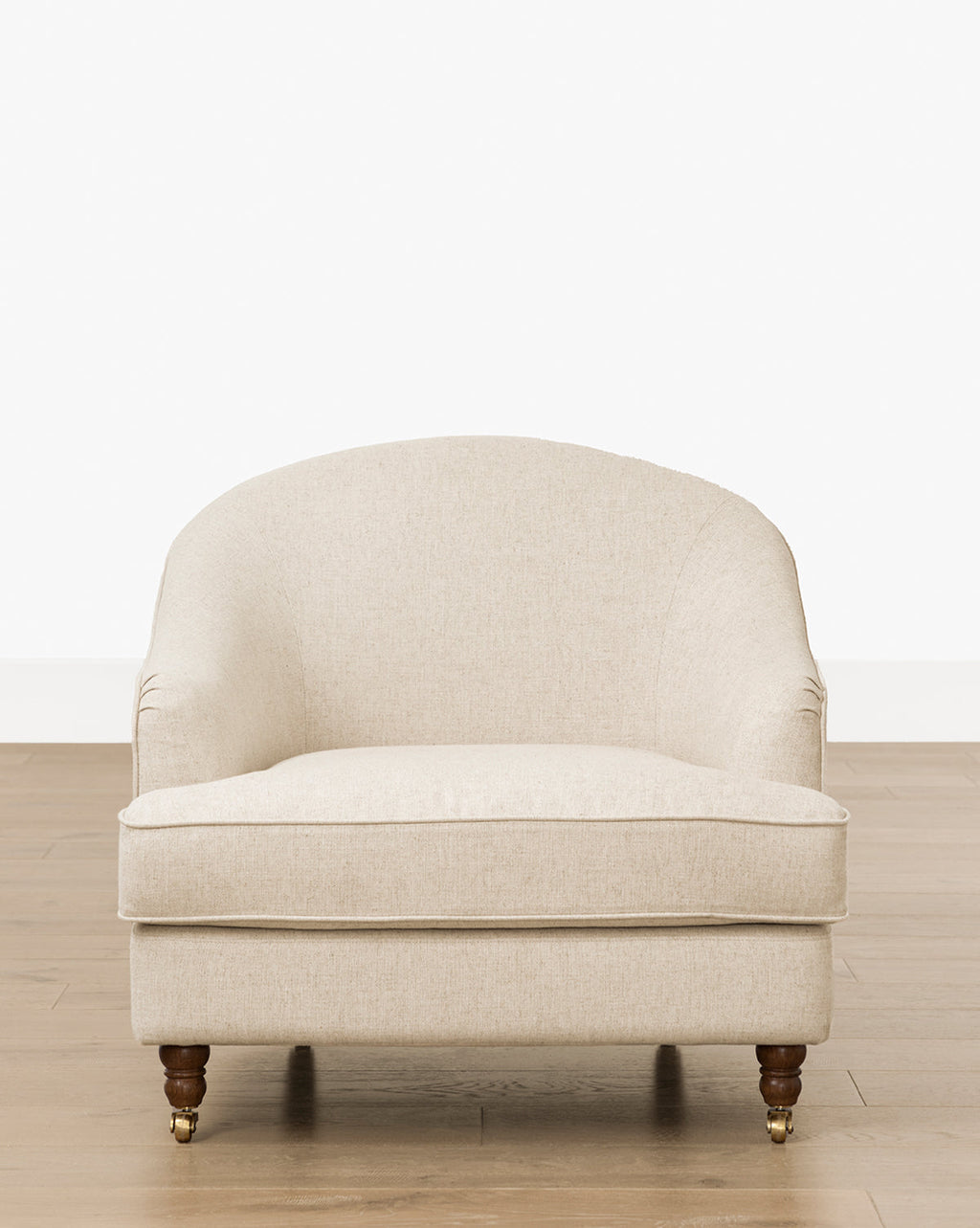 Fauteuil de salon classique capitonné avec accoudoirs roulés et pieds à roulettes pour salon