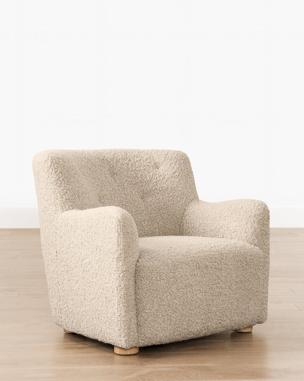 Fauteuil bas en peau de mouton contemporain avec structure en chêne blanc et capitonnage subtil pour le salon