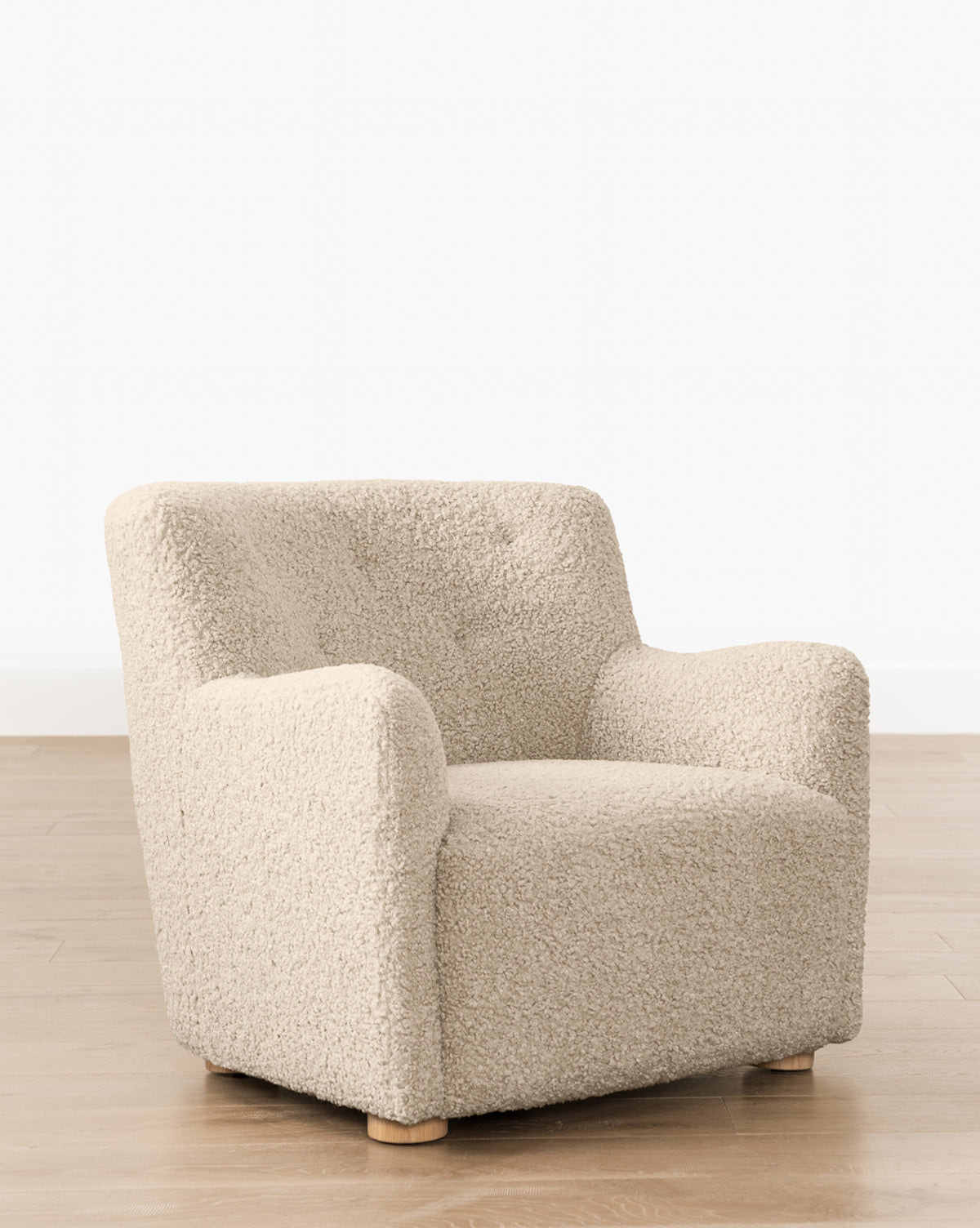 Fauteuil bas en peau de mouton contemporain avec structure en chêne blanc et capitonnage subtil pour le salon
