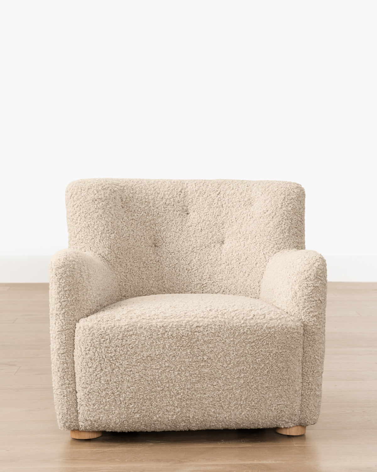 Fauteuil bas en peau de mouton contemporain avec structure en chêne blanc et capitonnage subtil pour le salon