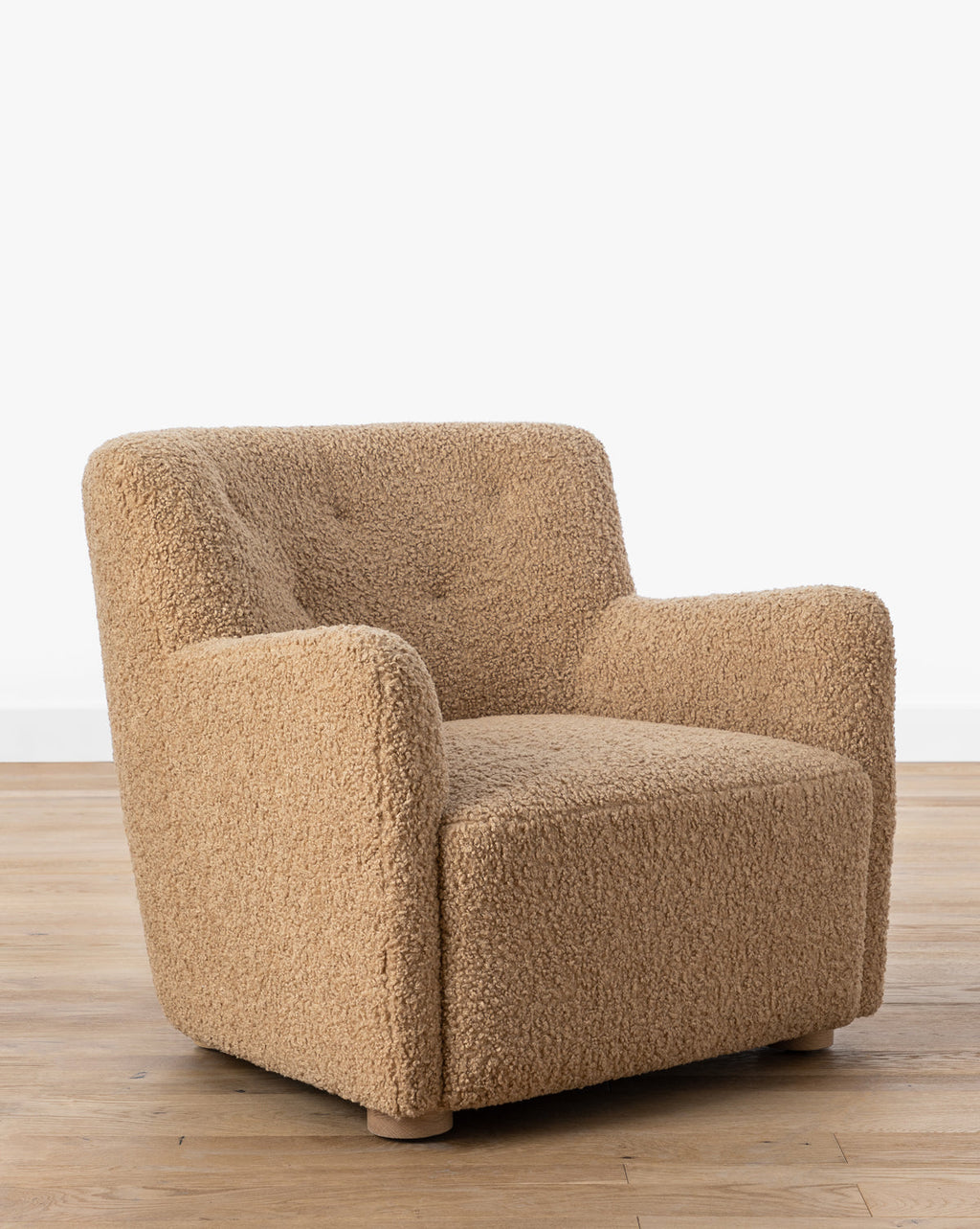 Fauteuil bas en peau de mouton contemporain avec structure en chêne blanc et capitonnage subtil pour le salon