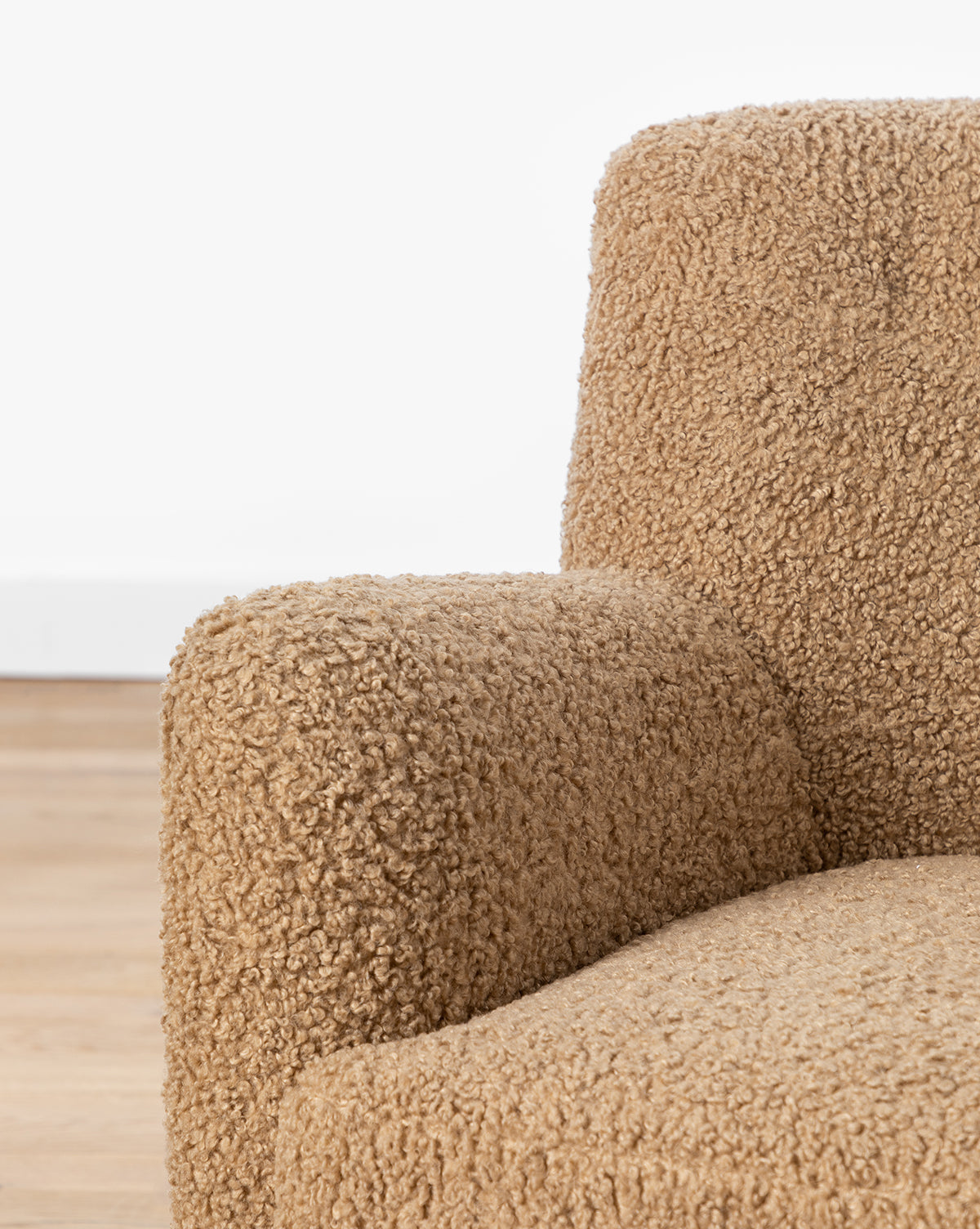 Fauteuil bas en peau de mouton contemporain avec structure en chêne blanc et capitonnage subtil pour le salon